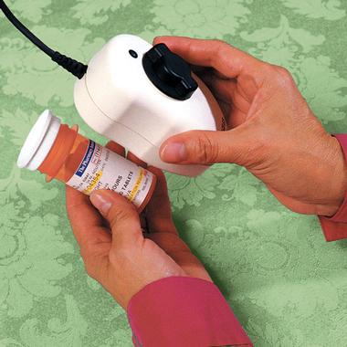 Woman's hands hold the Max Digital 'Handeld' Magnifier to read the small print on a prescription pill container's label
