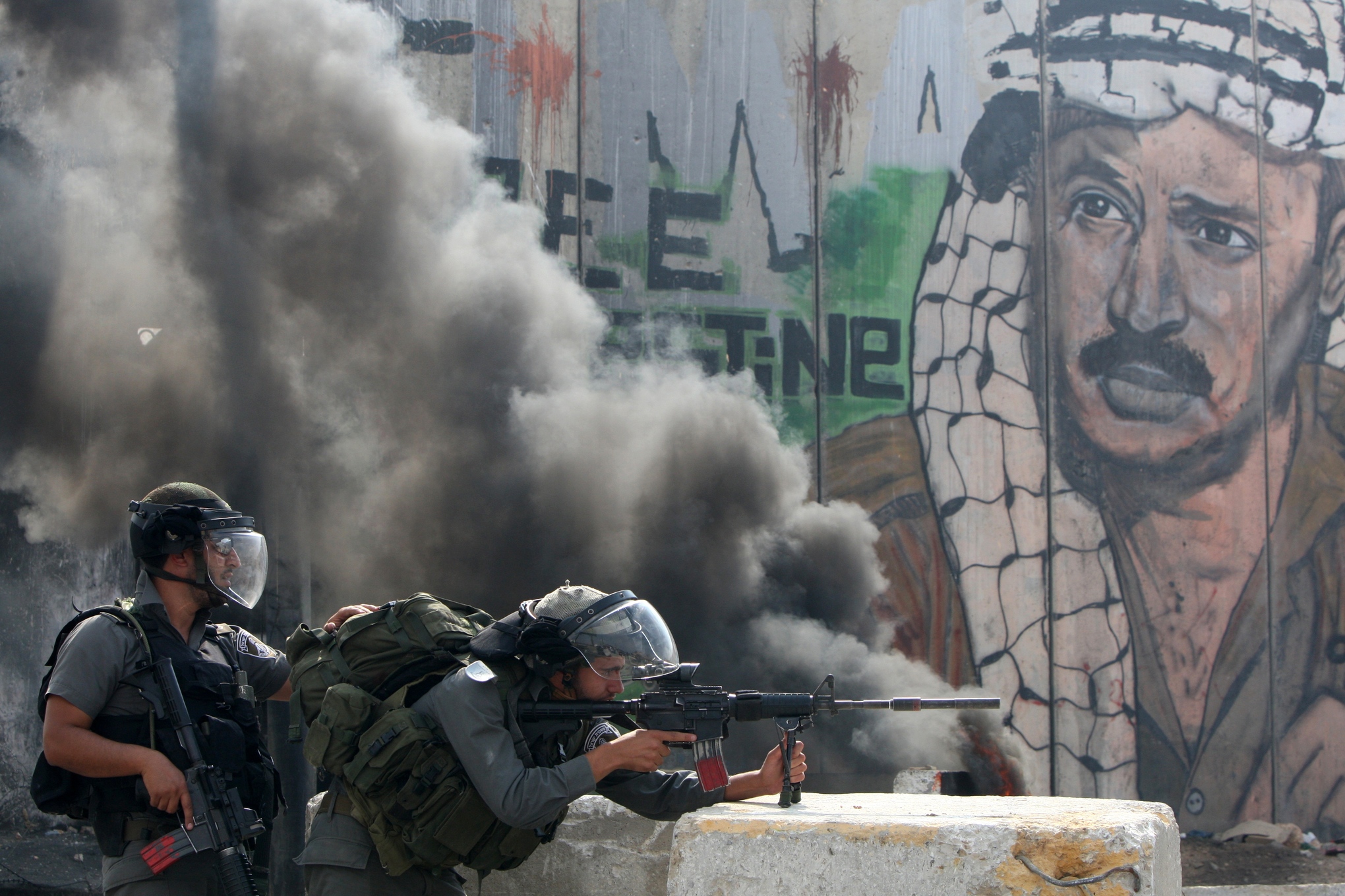 Retrato de Arafat al fondo de dos soldados de las Fuerzas de Defensa de Israel