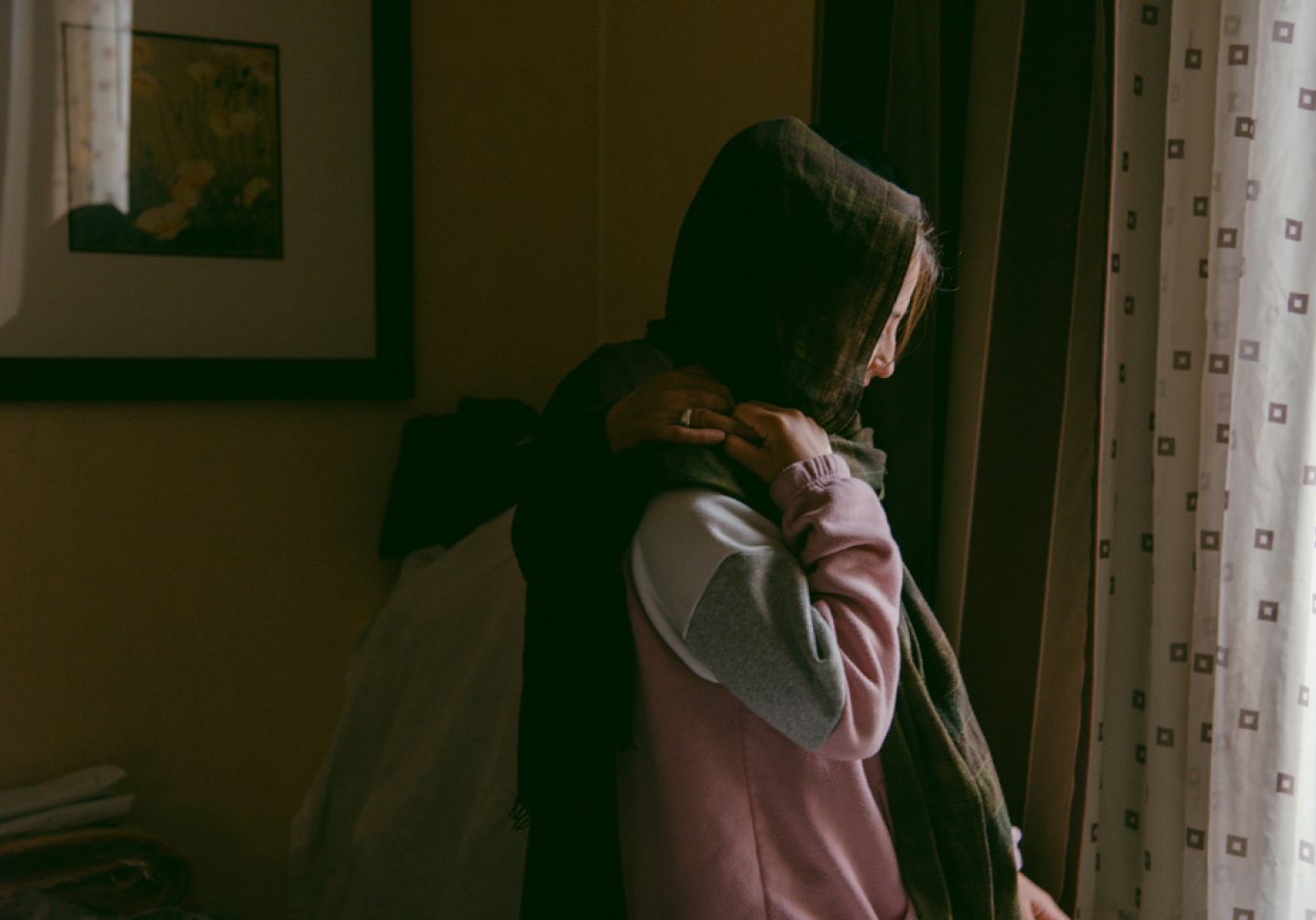 An Afghan woman who asked not to be identified holds hands with her great-niece at a hotel room in Turlock, California. Upon evacuating to the United States, she learned that she has an advanced form of cancer, which she says has put additional strain on her and her family.