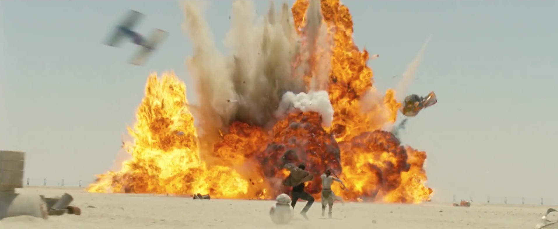 A TIE Fighter causes an explosion, as Rey and Finn run away